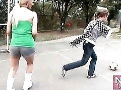 Two chicks with big tits kick around a ball outdoors